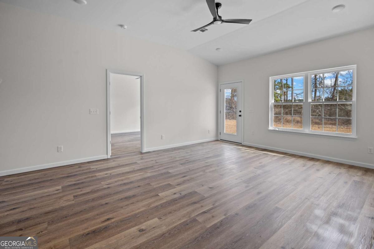 96 Beech Road Hazlehurst, GA 31539 - Photo 21 of 32 a view of an empty room with a window and wooden floor