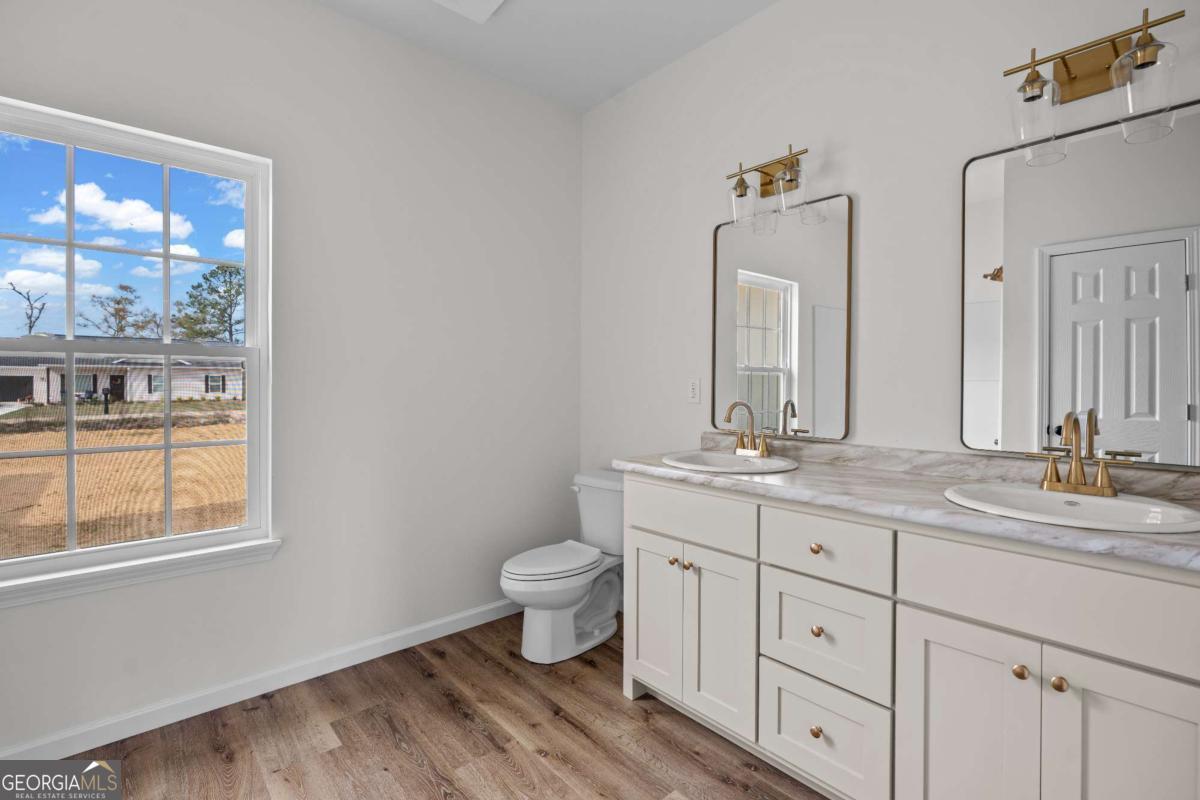 96 Beech Road Hazlehurst, GA 31539 - Photo 25 of 32 a bathroom with double vanity sink a mirror and a toilet