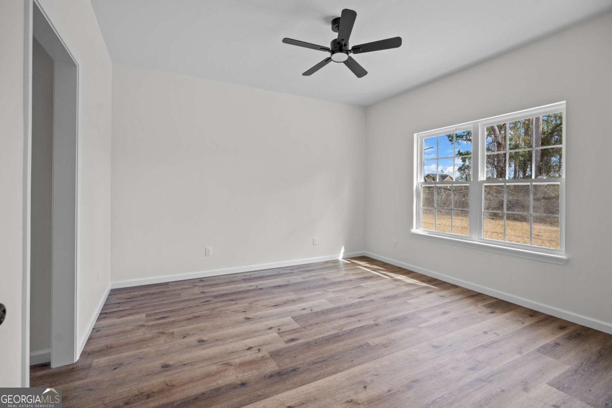 96 Beech Road Hazlehurst, GA 31539 - Photo 27 of 32 a view of an empty room with wooden floor and a window