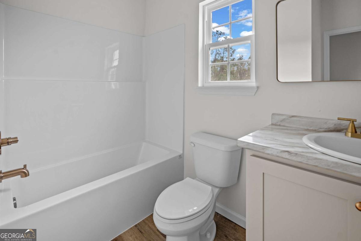 96 Beech Road Hazlehurst, GA 31539 - Photo 28 of 32 a white toilet sitting next to a bath tub