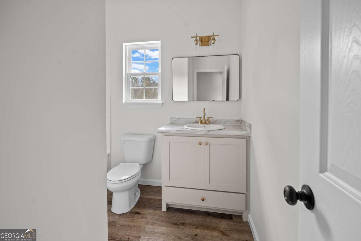 96 Beech Road Hazlehurst, GA 31539 - Photo 31 of 32 a bathroom with a toilet sink and mirror