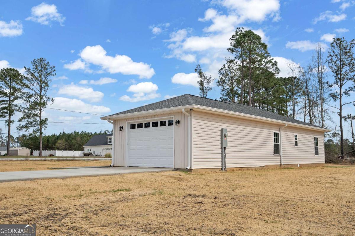 96 Beech Road Hazlehurst, GA 31539 - Photo 5 of 32 a view of a white house with a yard and garage