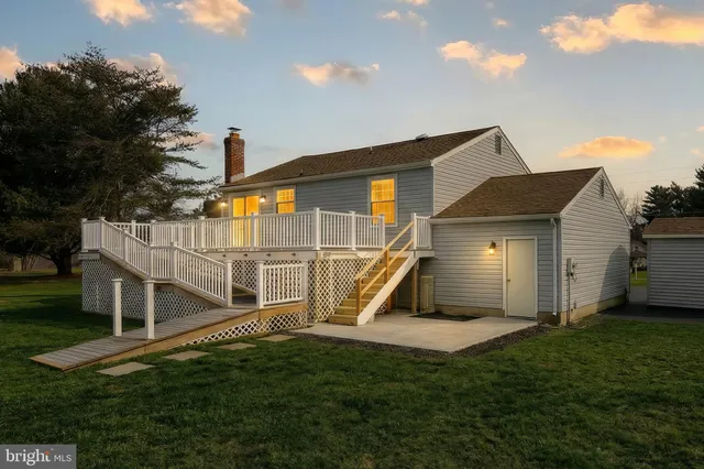 a view of an house with backyard and a tree