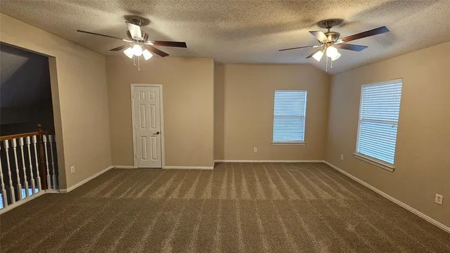 a view of an empty room with a chandelier fan