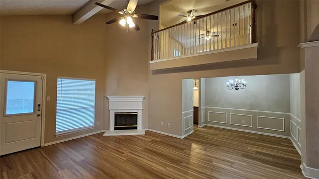 a view of a livingroom with wooden floor fireplace and staircase
