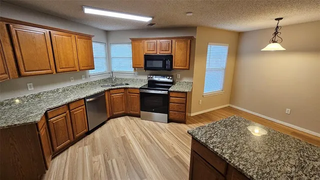 a kitchen with granite countertop wooden cabinets and a granite counter tops