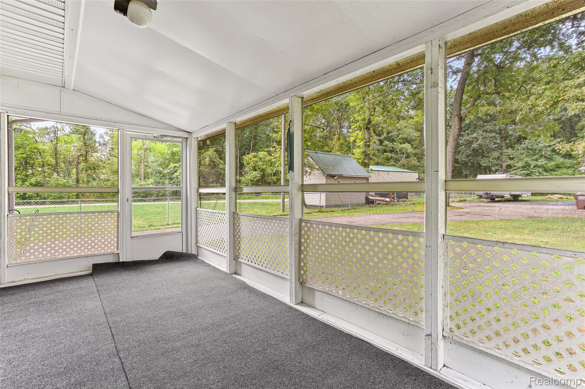 9561 Exeter Road Carleton, MI 48117 - Photo 33 of 46 Enclosed screened porch with a vaulted ceiling, recessed lighting fixture, and durable flooring