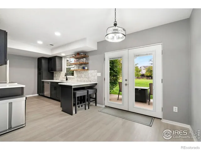 a kitchen with kitchen island stainless steel appliances a sink cabinets and wooden floor