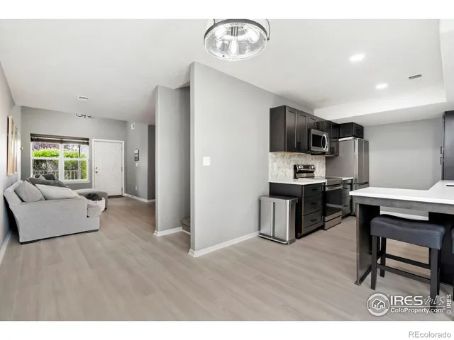 a open kitchen with cabinets wooden floor and stainless steel appliances