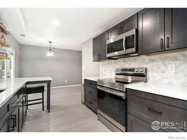 a kitchen with stainless steel appliances kitchen island granite countertop a stove and a microwave