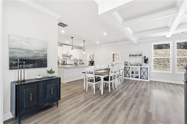 a dining hall with stainless steel appliances granite countertop a stove and a wooden floors