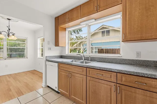 a kitchen with granite countertop white cabinets and window