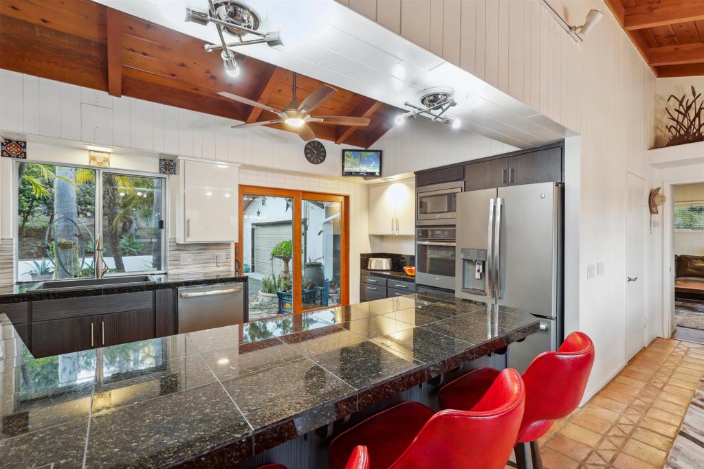 826 Ora Avo Drive Vista, CA 92084 - Photo 10 of 52 a kitchen with stainless steel appliances kitchen island granite countertop a refrigerator a stove and a sink with granite countertops