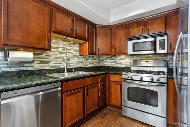 a kitchen with granite countertop a sink and cabinets