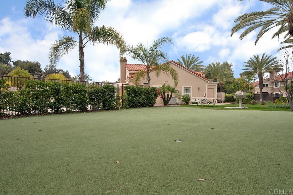 102 Sea Cliff Way Oceanside, CA 92056 - Photo 35 of 44 a view of a white house with a yard and palm trees