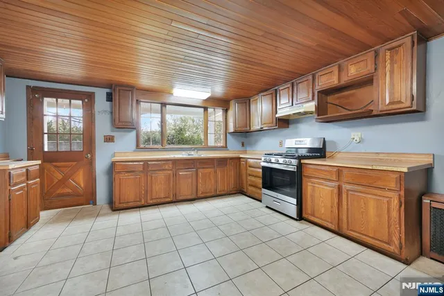 a kitchen with stainless steel appliances granite countertop a stove sink and cabinets