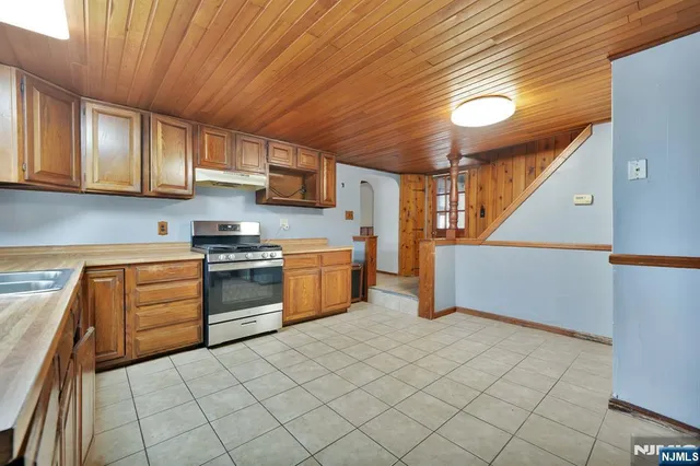 a kitchen with a sink a stove top oven and cabinets