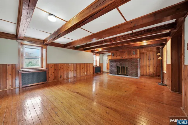 a view of empty room with wooden floor and fireplace