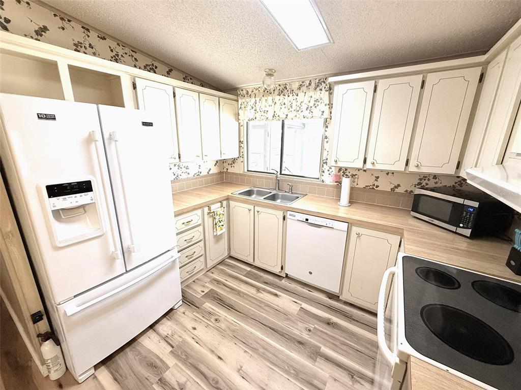 122 Rarotonga Road North Port, FL 34287 - Photo 13 of 48 a kitchen with a white stove top oven sink and window