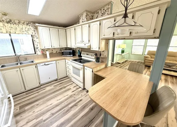 a kitchen with white cabinets and white appliances
