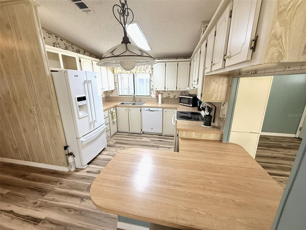 122 Rarotonga Road North Port, FL 34287 - Photo 15 of 48 a kitchen with white cabinets and white appliances