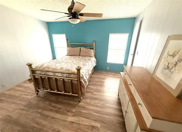 a spacious bedroom with a bed and a chandelier
