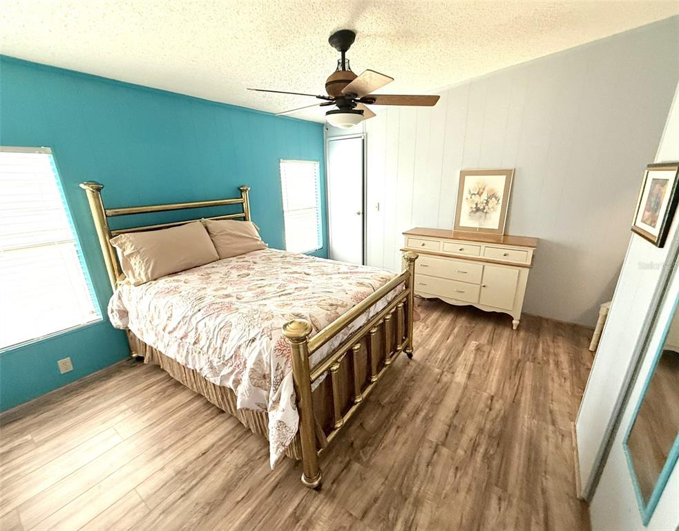 122 Rarotonga Road North Port, FL 34287 - Photo 22 of 48 a spacious bedroom with a bed and a chandelier