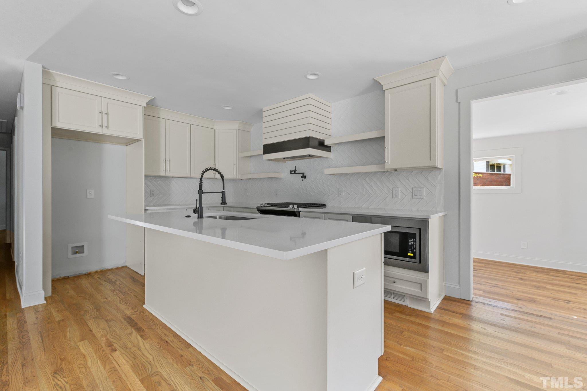 317 Quail Drive Raleigh, NC 27604 - Photo 14 of 29 a kitchen with stainless steel appliances granite countertop a sink a stove and a refrigerator