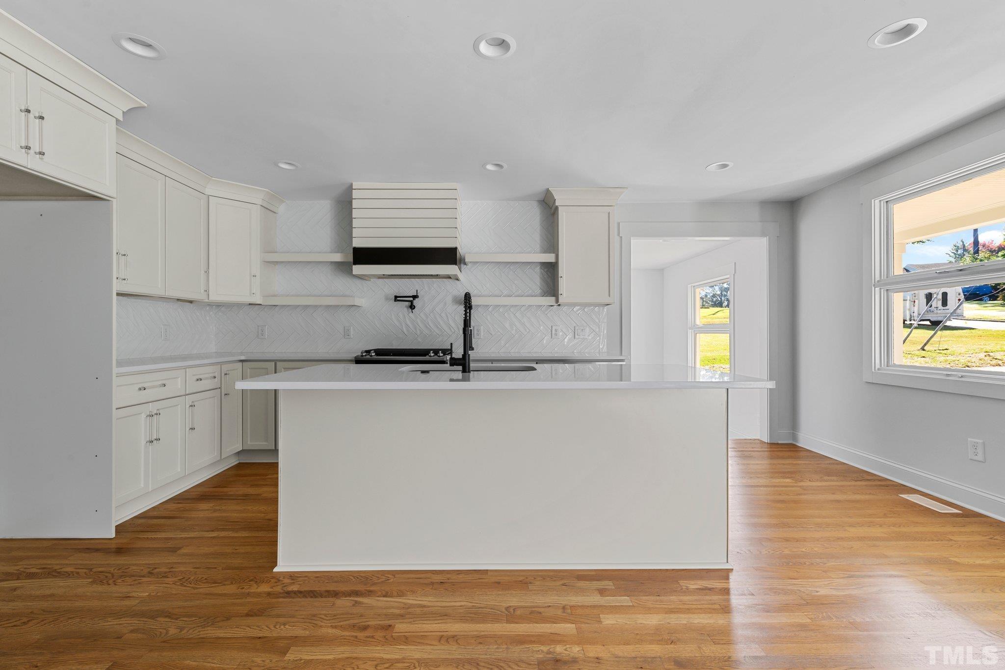 317 Quail Drive Raleigh, NC 27604 - Photo 15 of 29 a kitchen with stainless steel appliances granite countertop a sink cabinets and wooden floor