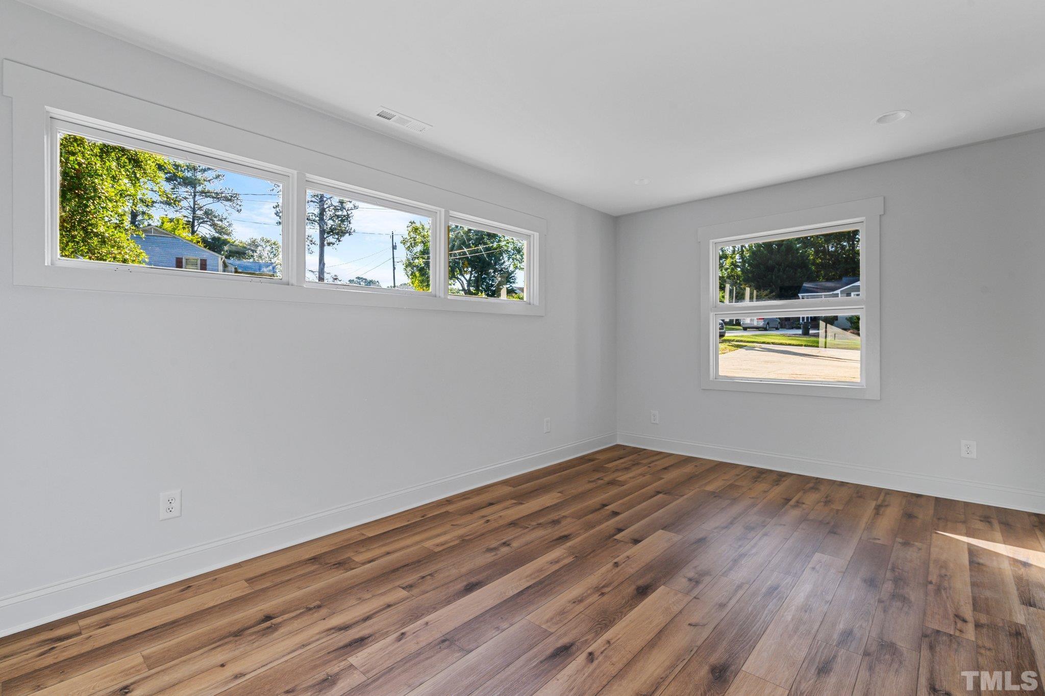 317 Quail Drive Raleigh, NC 27604 - Photo 20 of 29 a view of empty room with window and wooden floor