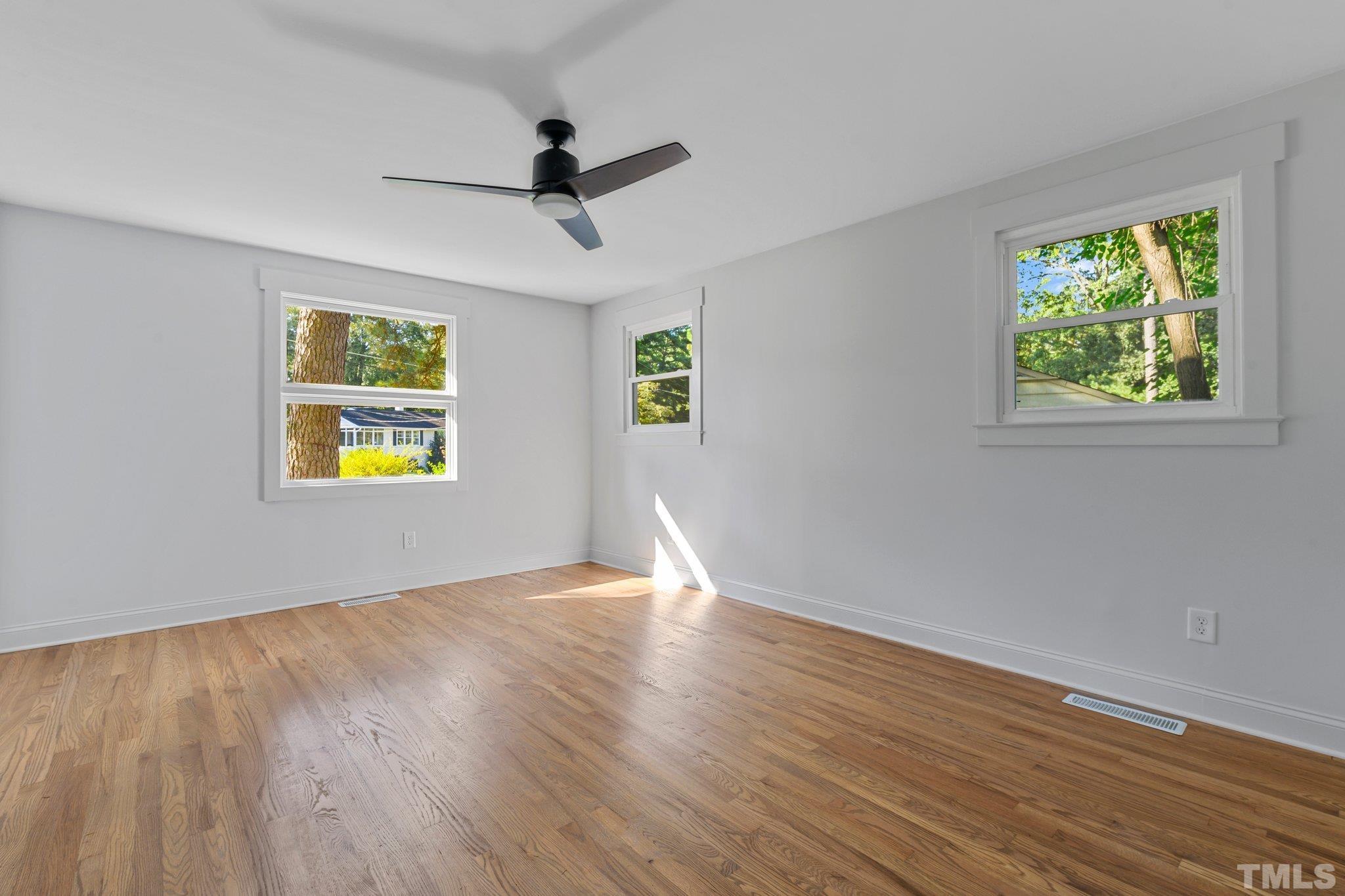 317 Quail Drive Raleigh, NC 27604 - Photo 7 of 29 a view of an empty room with wooden floor and a window