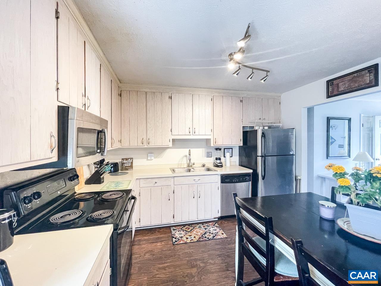 39 East Daffodil Road Ruckersville, VA 22968 - Photo 13 of 28 a kitchen with a refrigerator a stove a sink dishwasher a dining table and chairs with wooden floor
