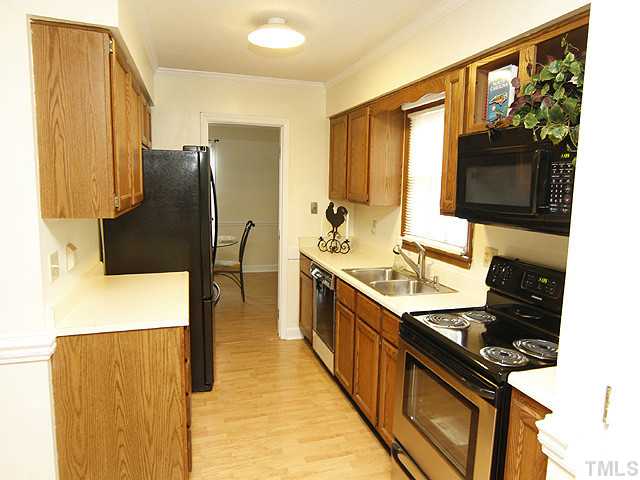 6800 Glendower Road Raleigh, NC 27613 - Photo 5 of 14 a kitchen with stainless steel appliances a stove a sink and a refrigerator
