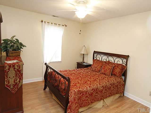 6800 Glendower Road Raleigh, NC 27613 - Photo 8 of 14 a bedroom with a bed and a chandelier