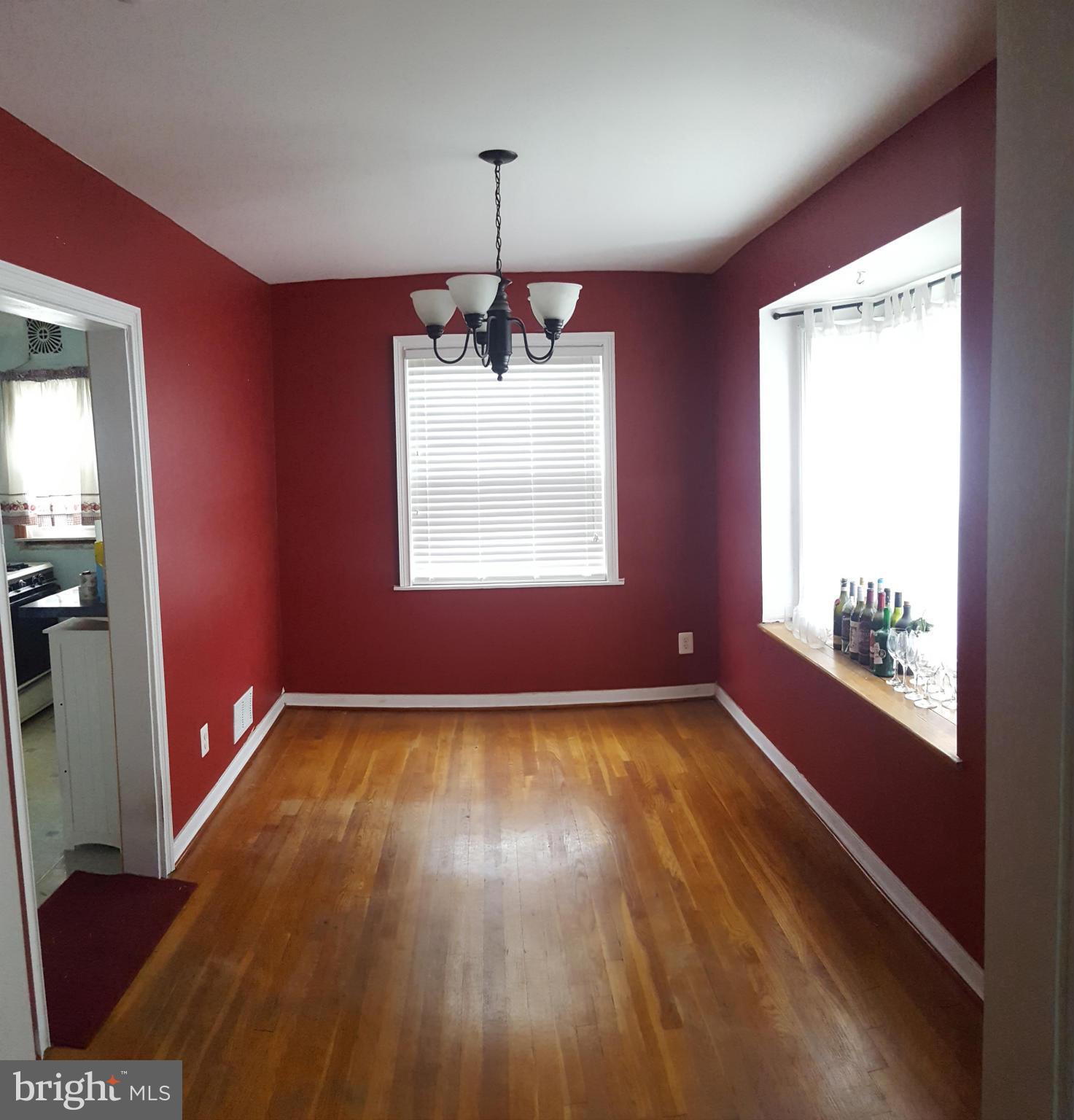 824 Arncliffe Road Baltimore, MD 21221 - Photo 3 of 7 a view of an empty room with wooden floor and a window
