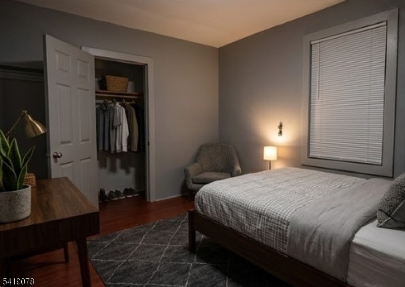 73 4th Street, Unit B1 Passaic, NJ 07055 - Photo 2 of 12 a bedroom with a bed a desk and chair