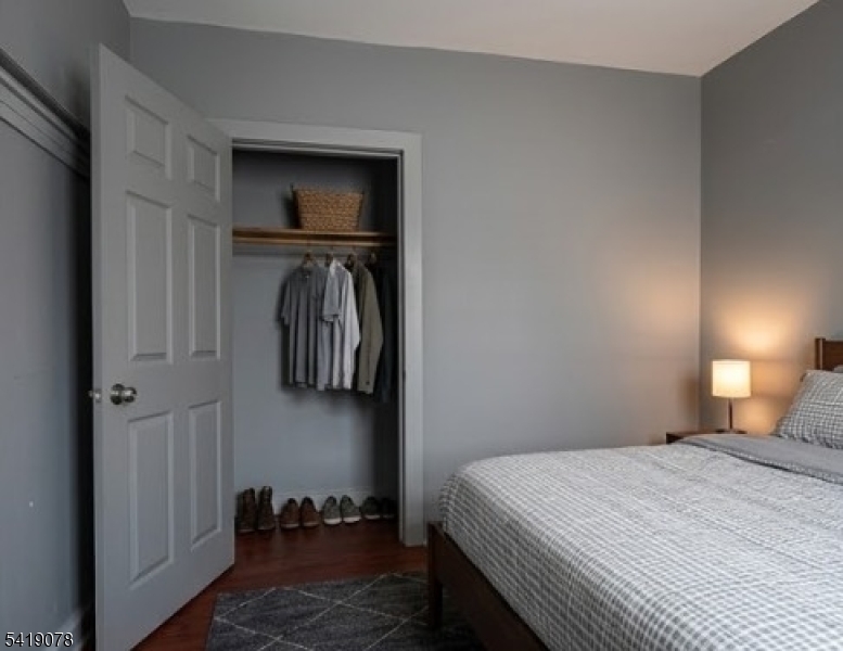 73 4th Street, Unit B1 Passaic, NJ 07055 - Photo 3 of 12 a bedroom with a bed and a mirror