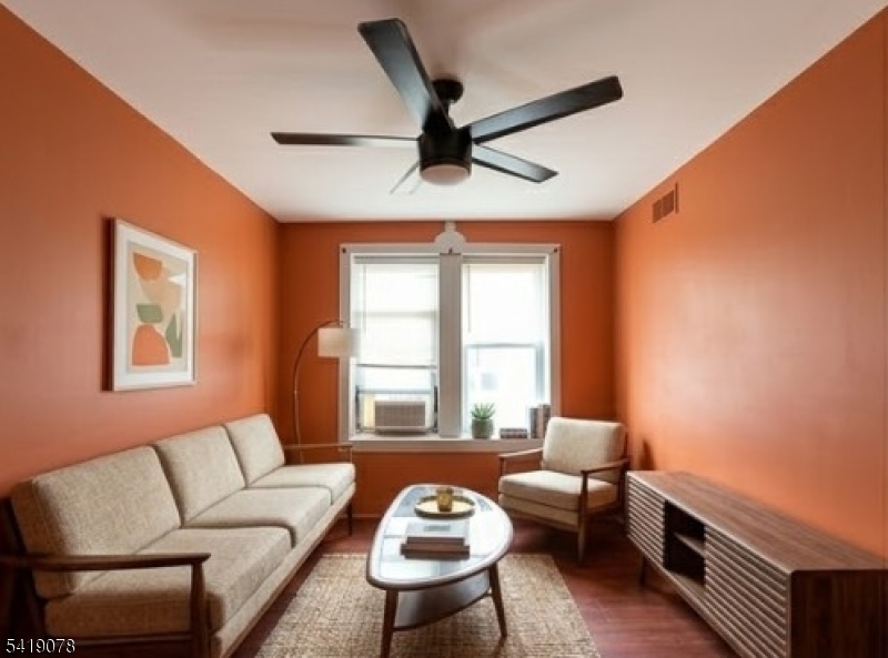 73 4th Street, Unit B1 Passaic, NJ 07055 - Photo 5 of 12 a living room with furniture and a window