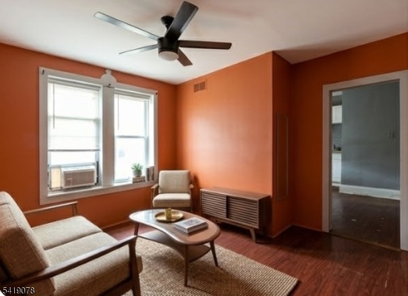 73 4th Street, Unit B1 Passaic, NJ 07055 - Photo 7 of 12 a living room with furniture and a window