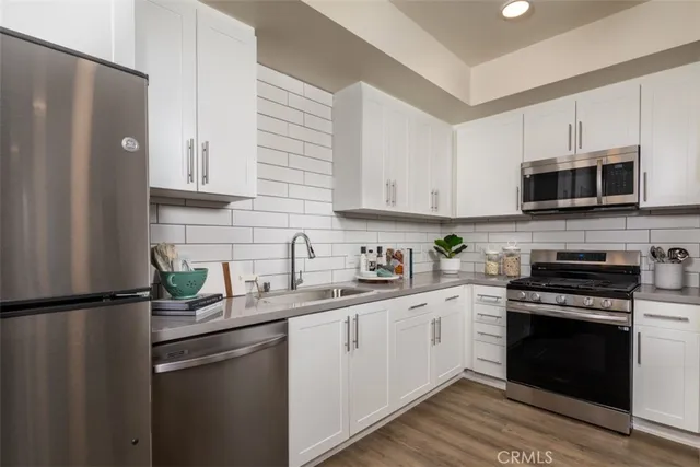 a kitchen with stainless steel appliances granite countertop a refrigerator sink and stove