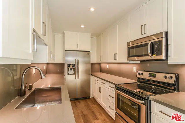 a kitchen with stainless steel appliances a stove a sink and a microwave