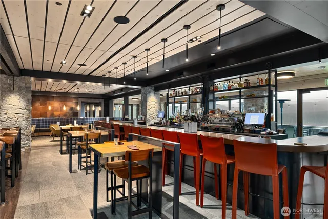 a dining hall with stainless steel appliances granite countertop a sink table and chairs