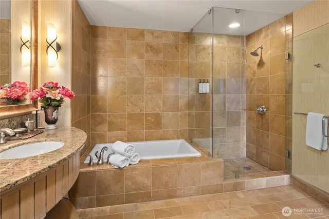 a bathroom with a granite countertop shower a sink and bathtub