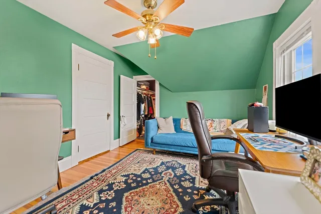 a bedroom with a bed and a flat tv screen on dresser