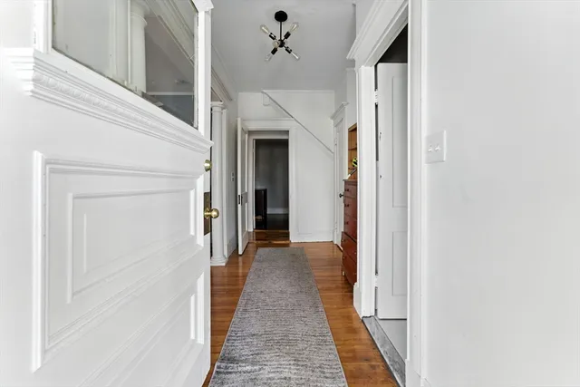 a view of a hallway with wooden floor and staircase