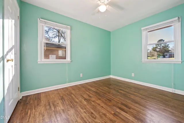 a view of a room with wooden floor and window