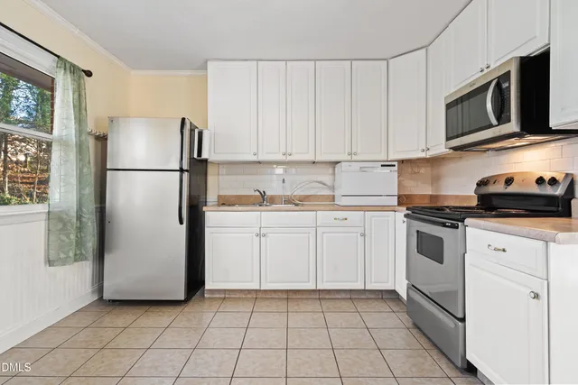 a kitchen with a refrigerator sink and cabinets