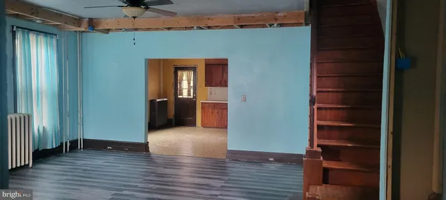 an empty room with wooden floor closet and windows