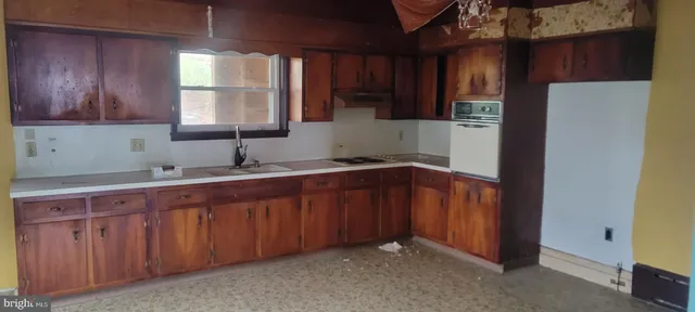 a kitchen with stainless steel appliances granite countertop wooden cabinets a sink and a window