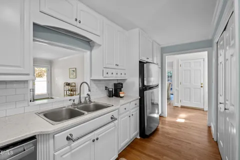 a kitchen with white cabinets and stainless steel appliances